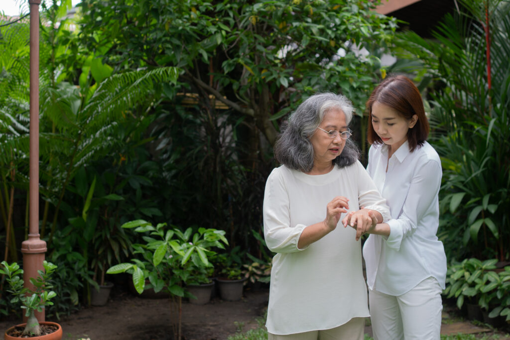 An older woman enjoying a walk in the garden with support.