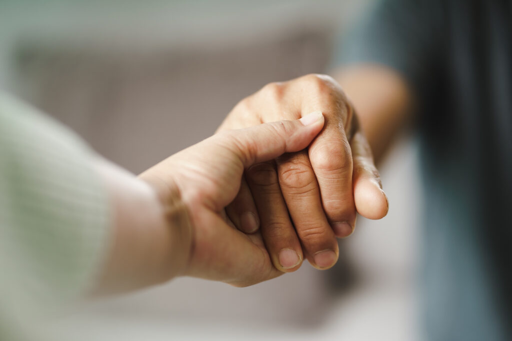 A close-up of hands held in reassurance.